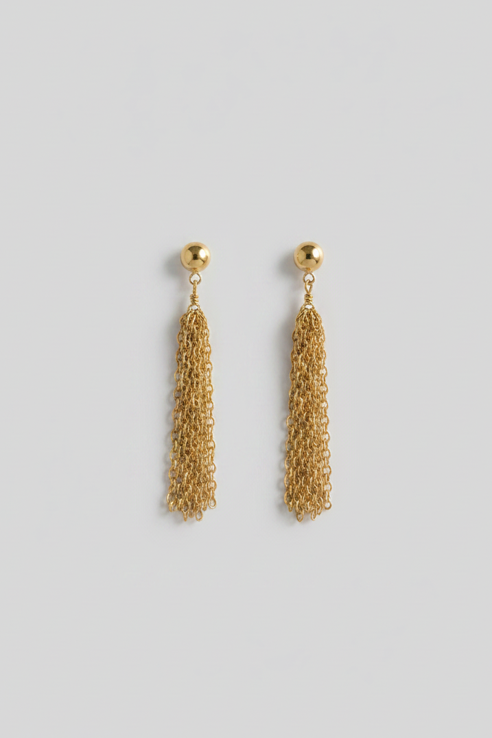 Gold chain tassel earrings on a black background